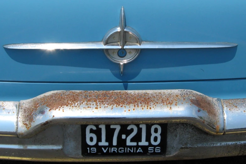 old blue car with rusted metal hood ornament