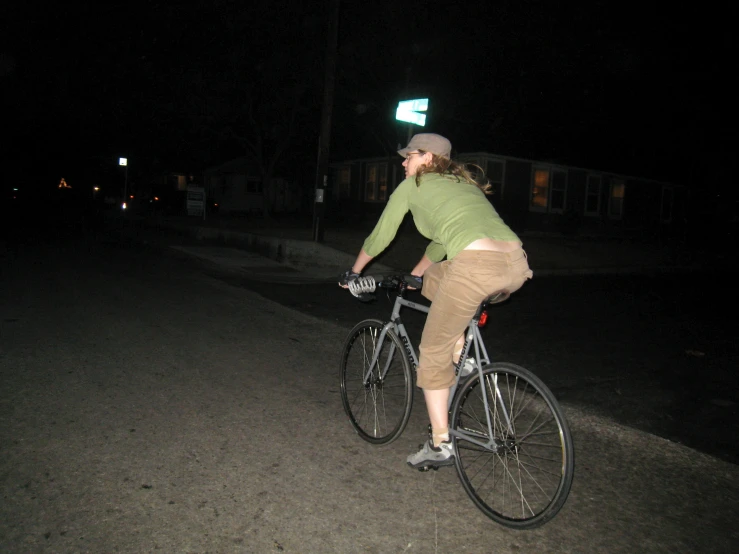 a person riding a bicycle in the dark