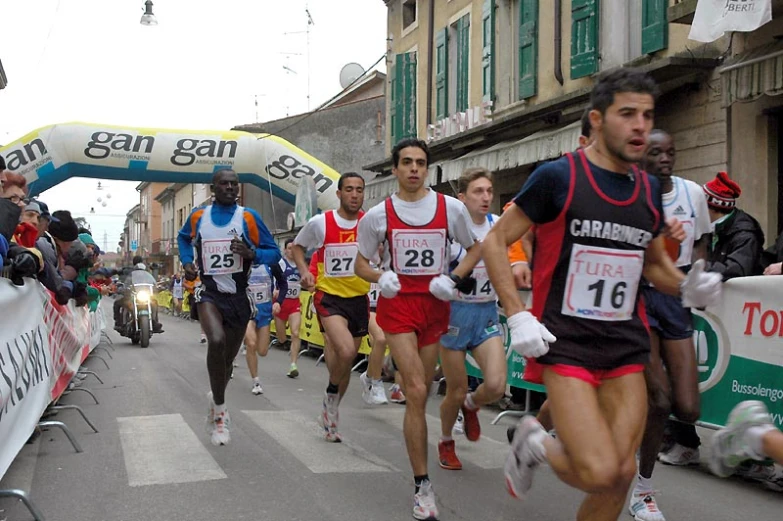 a race of men run along a city street