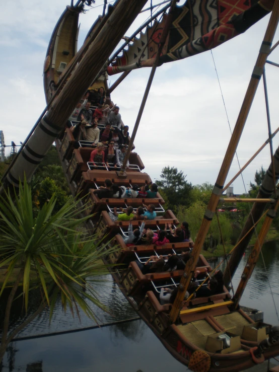 a carnival roller coaster on water with people riding it