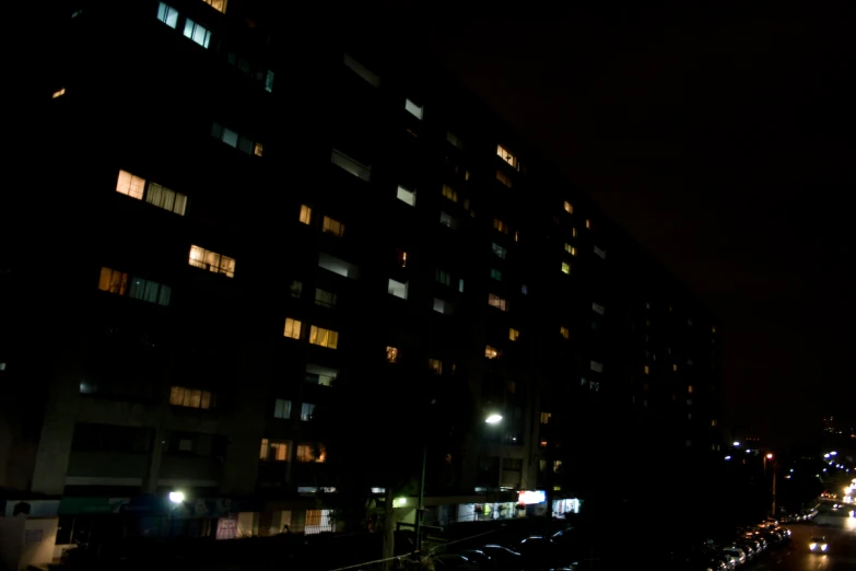 cars parked outside an apartment building in the dark