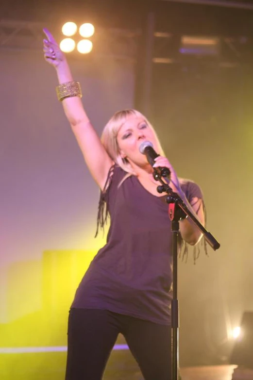 a woman singing into a microphone on stage