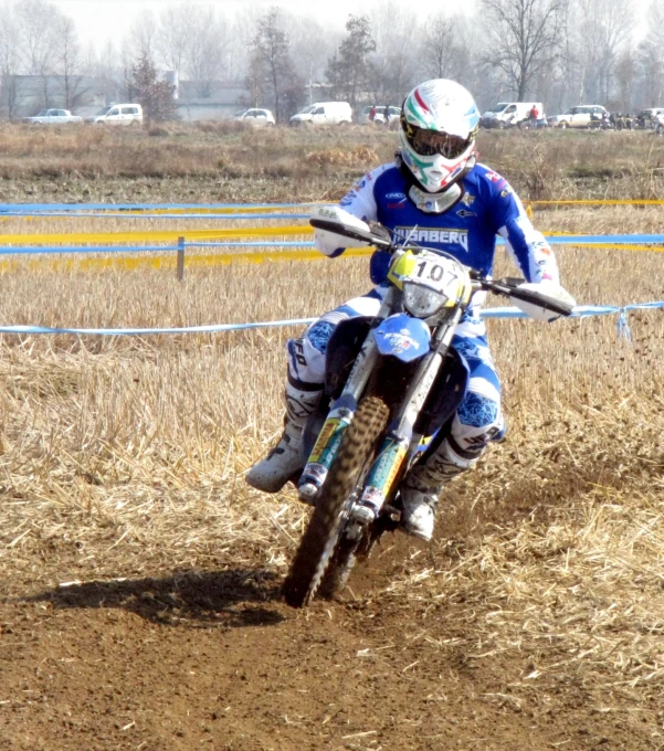 a guy riding a dirt bike around the corner