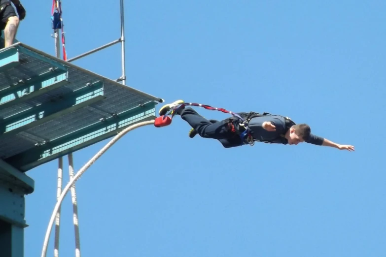 a person on a climbing rope suspended over a building