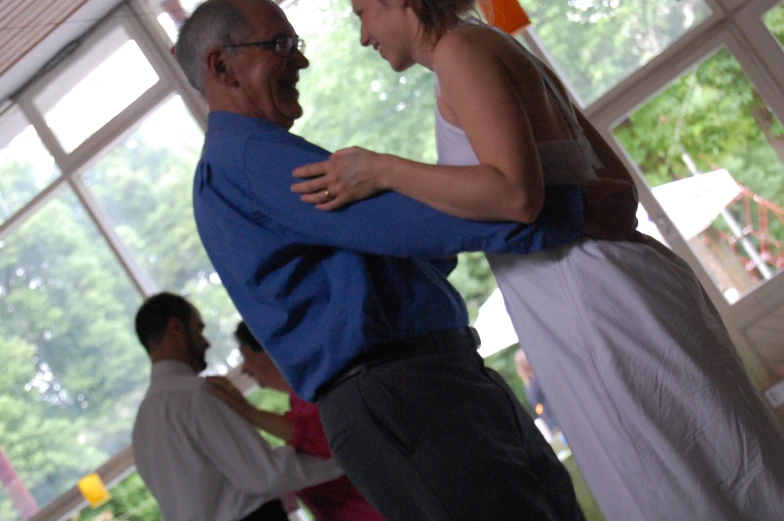 an older man hugging his younger man on a dance floor