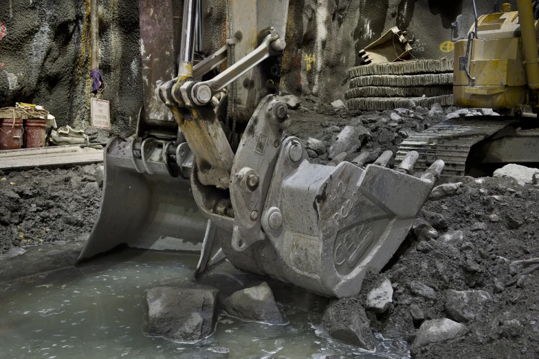 a heavy loader sits next to some rubble