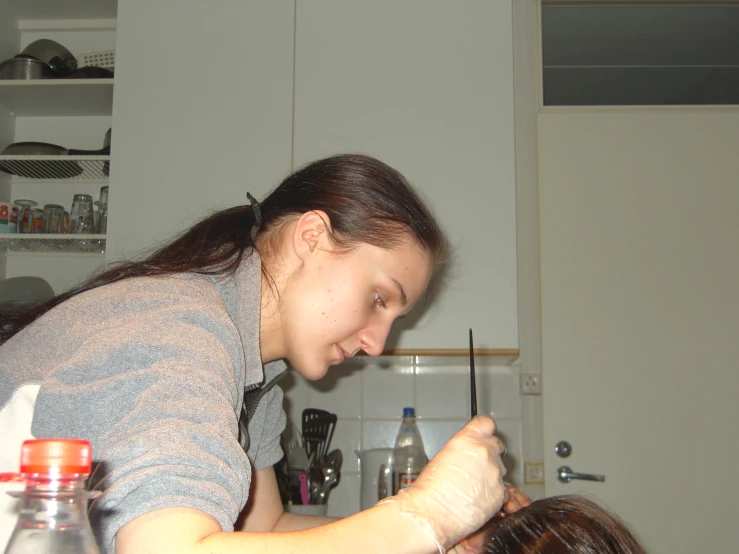 girl doing hair and make up in a kitchen