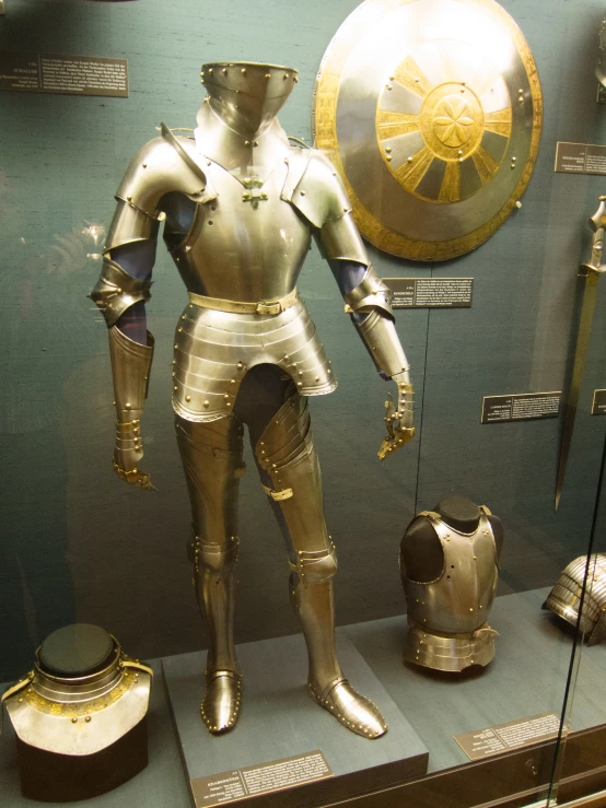 a metal armor and helmet with various types of weapons in display