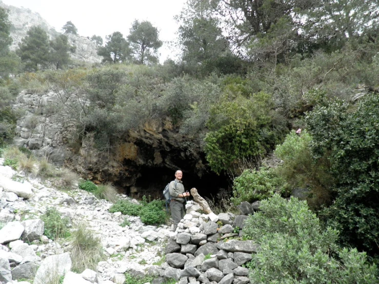 there is a man standing by a bunch of rocks