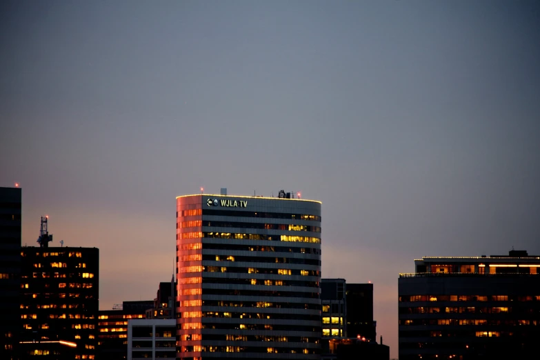 a city skyline with a lighted tower at dusk