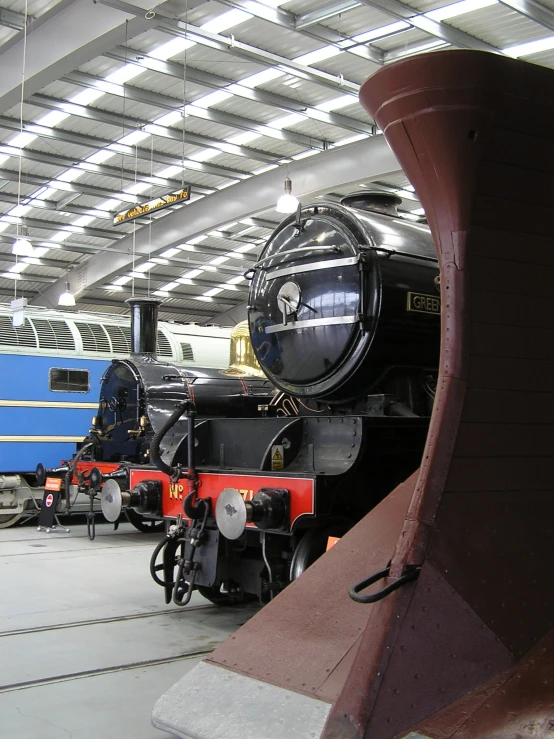 three trains are sitting on tracks in the train museum