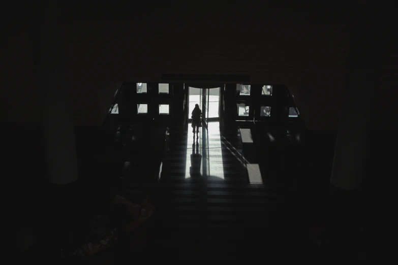 person standing at door with bright light coming through