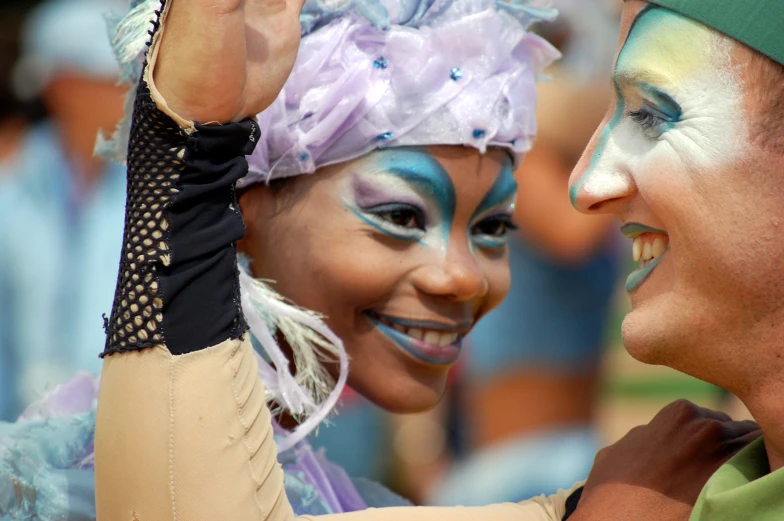 a close up of a woman with painted on her face and a man wearing face paint