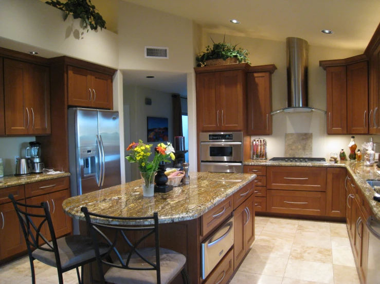 a kitchen with an island that has a vase of flowers on it