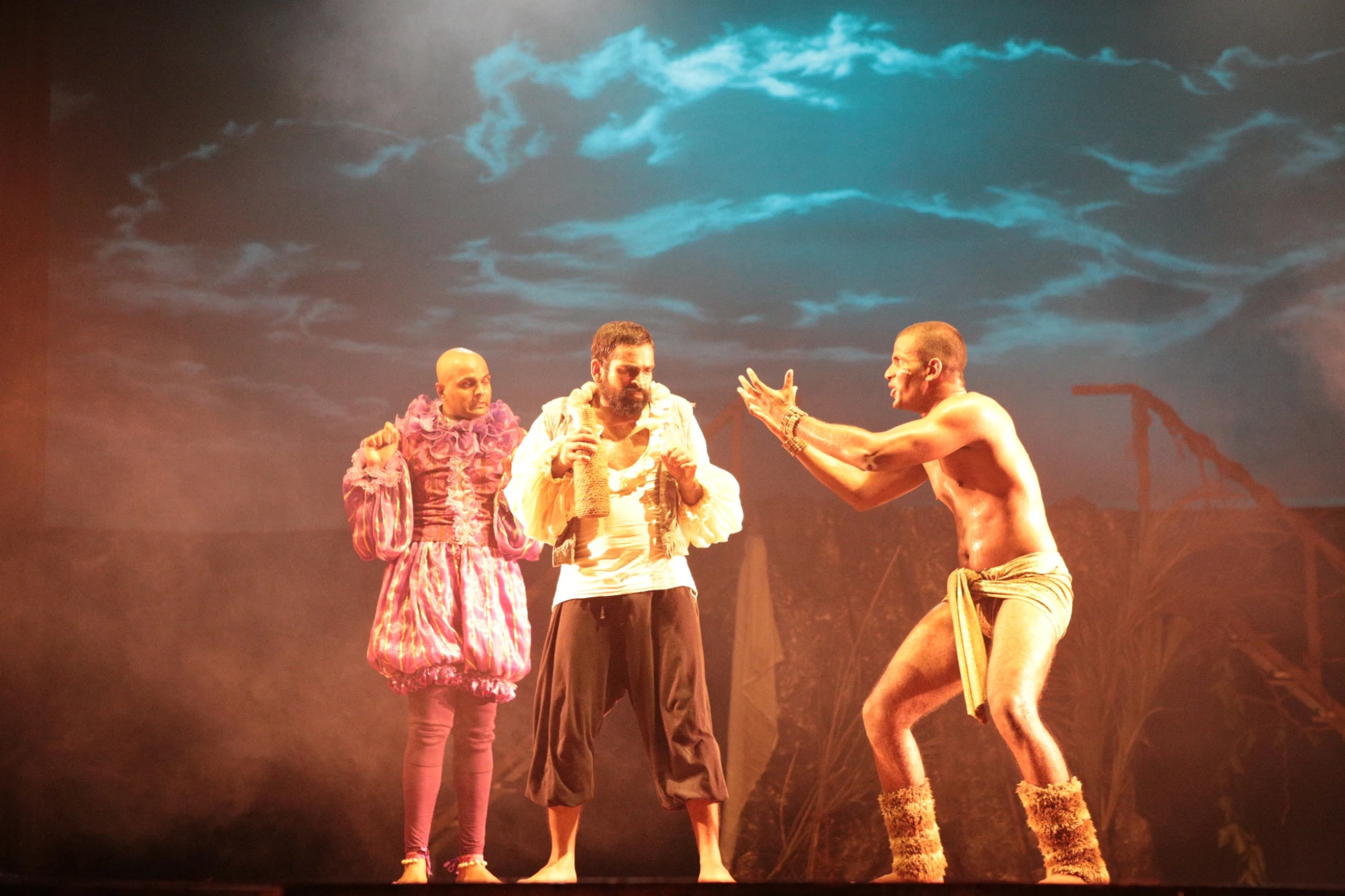 three people that are on stage with a cloudy sky