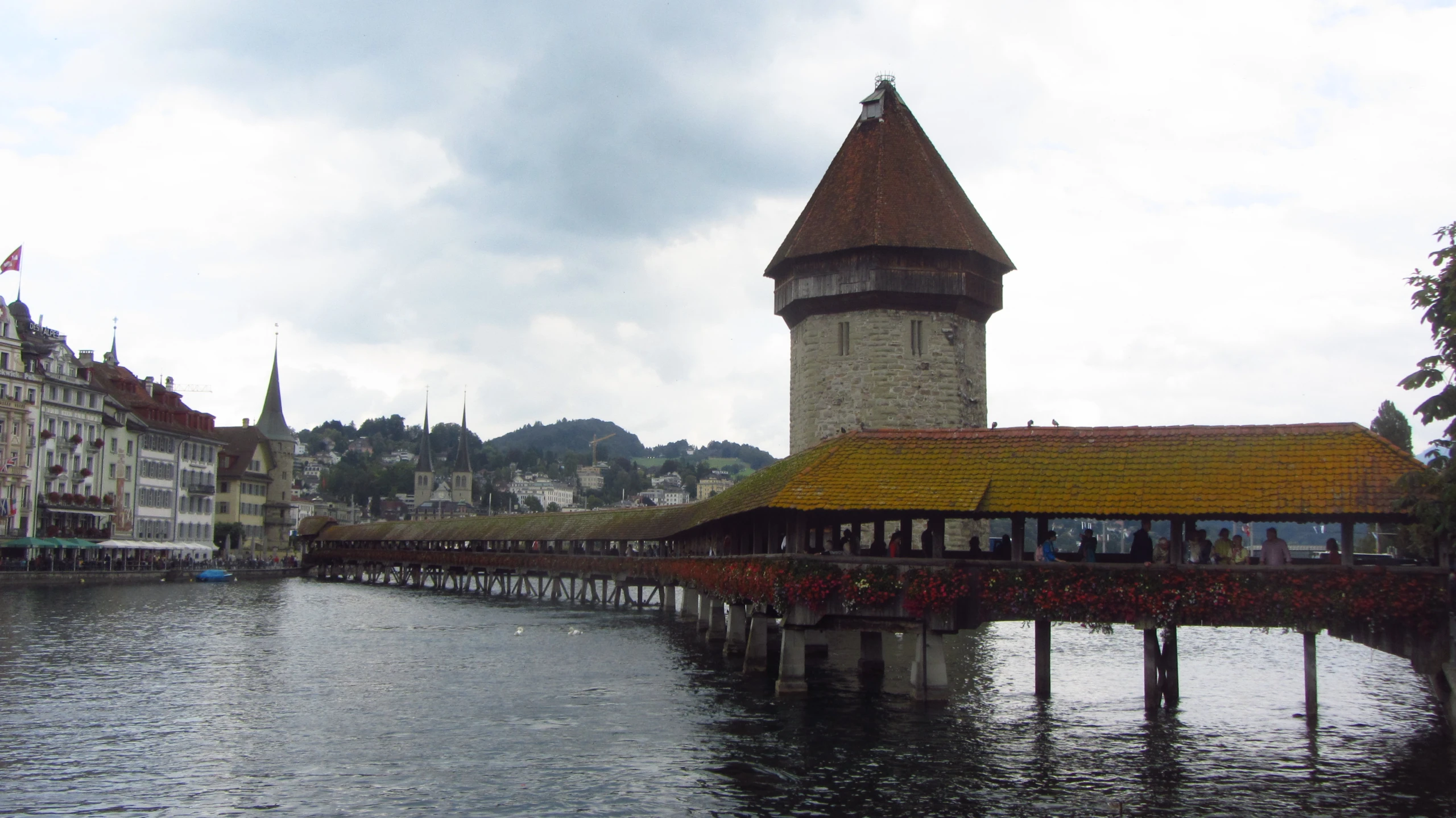 the water has a small bridge leading to a town tower