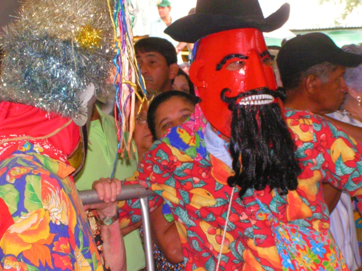 many people wearing brightly colored costumes and hats