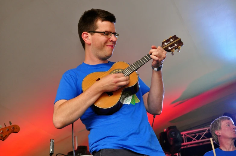 a man playing a guitar with a violin in front of him