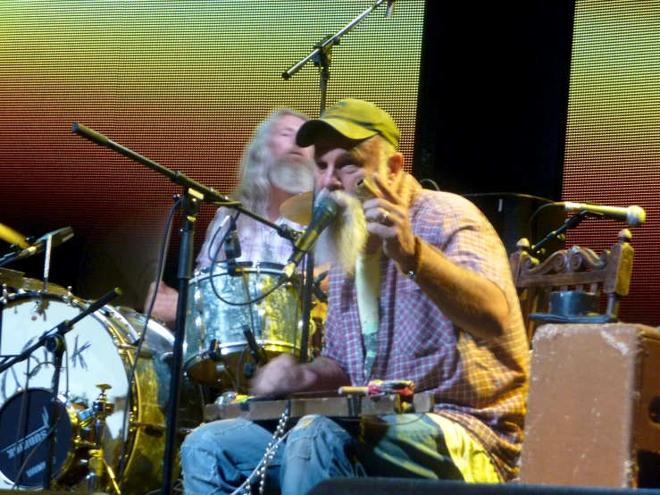 the man is sitting on stage with a drum