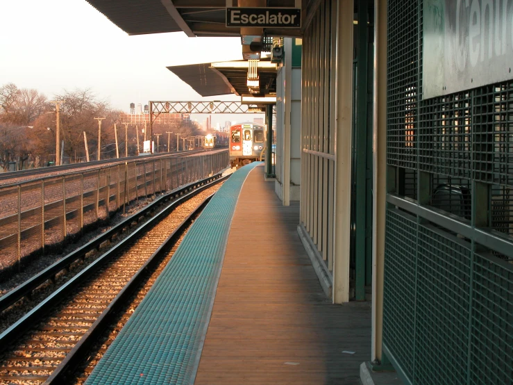 a train station with tracks and buildings and trees