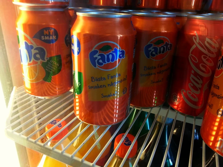bottles of orange juice on the shelves of a refrigerator