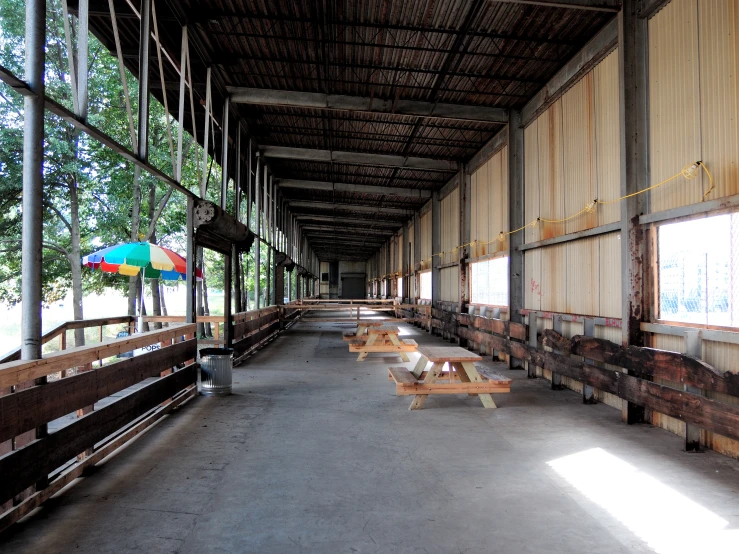 an empty covered area with benches and windows