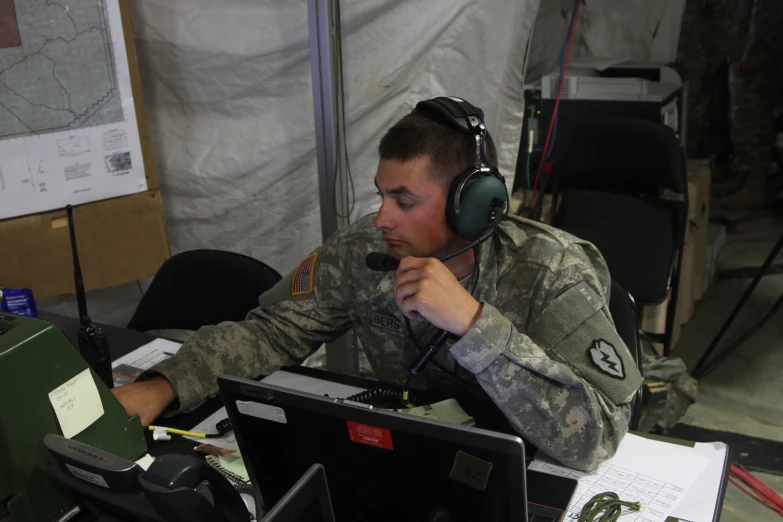 an officer is using a computer at his desk