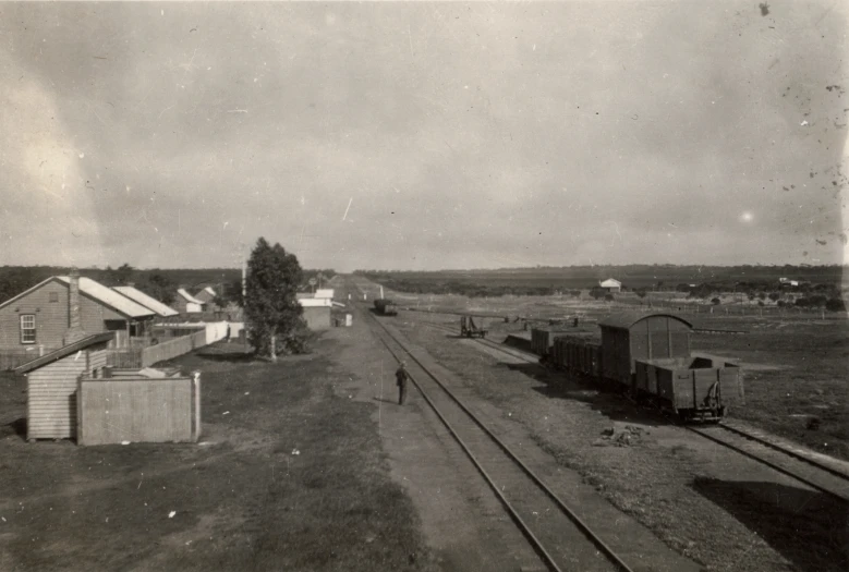 a sepia toned po of a railroad with old buildings