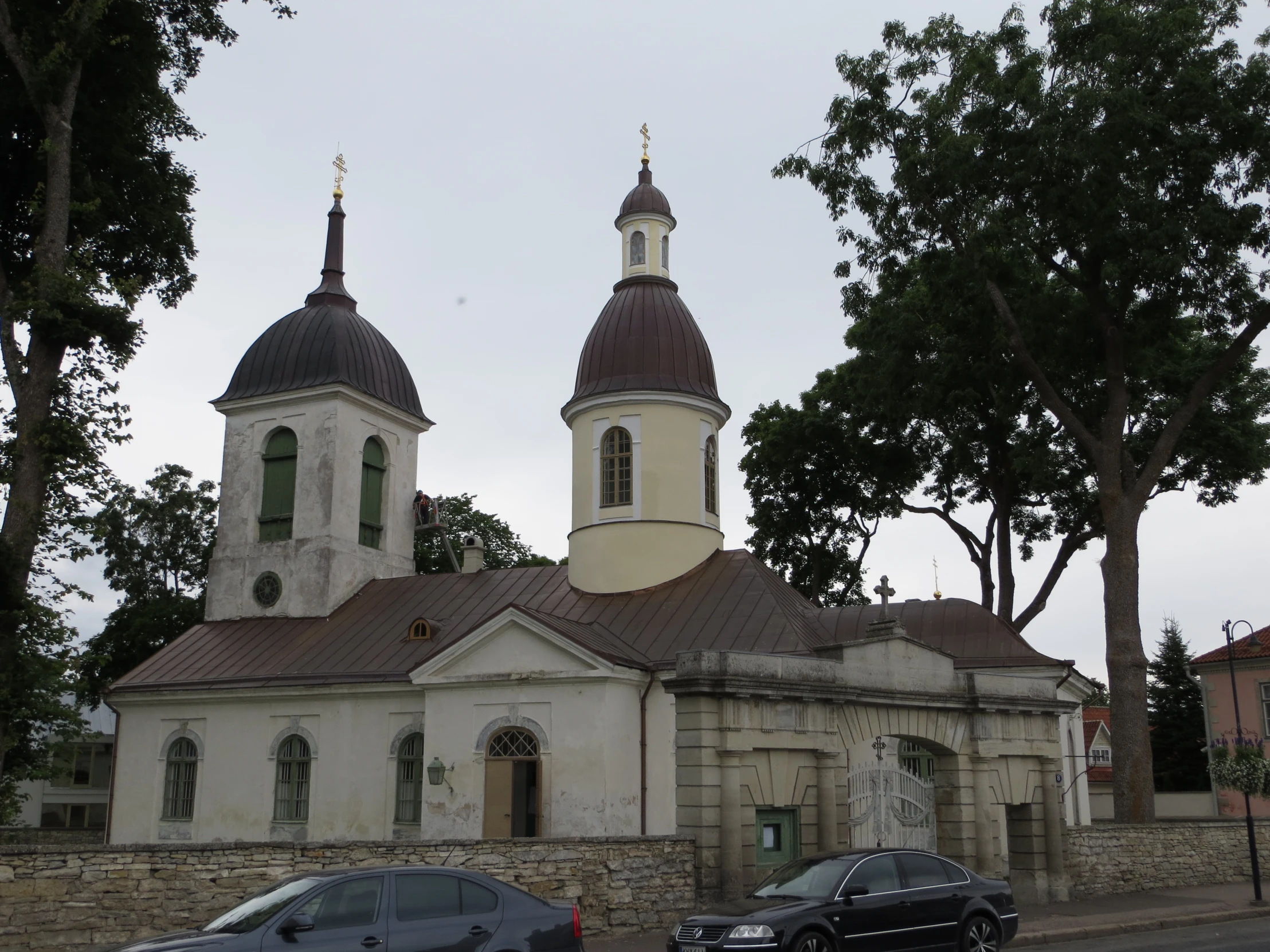 two cars parked by the curb of a small church