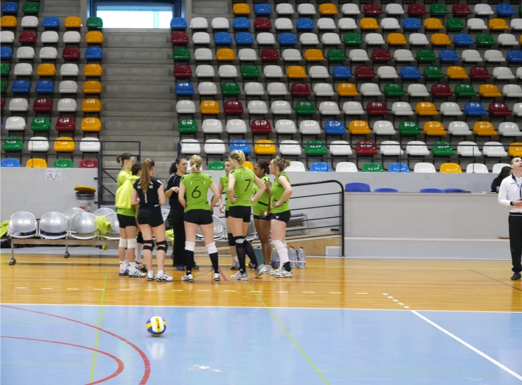 a group of female volleyball players standing on a court