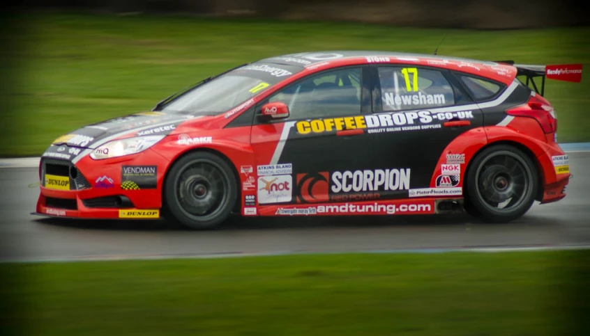 a red sports car is racing down the track