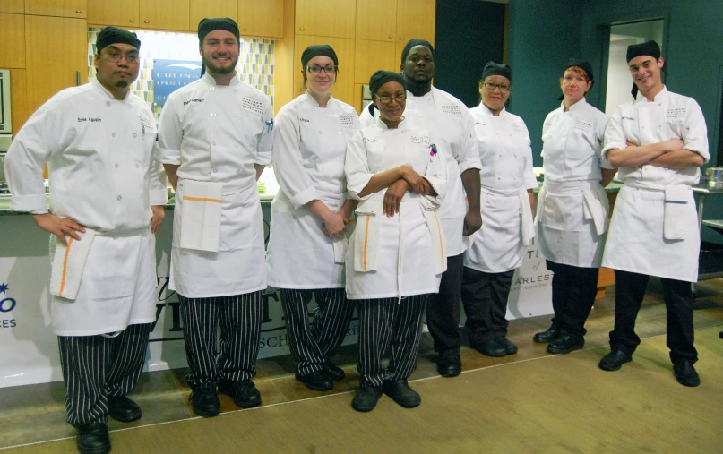 group of chefs posing for the camera in an office setting