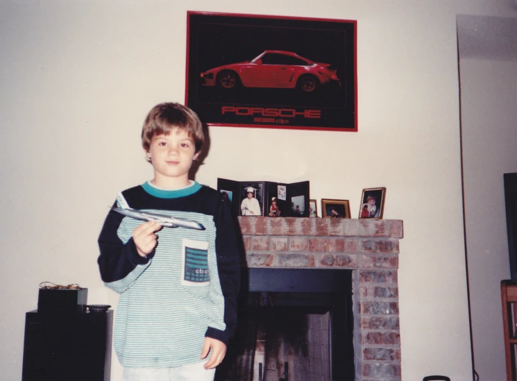 a young man is holding some material by a fireplace