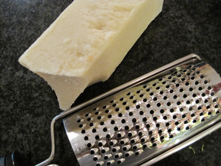 a grater that is on a counter near a piece of food