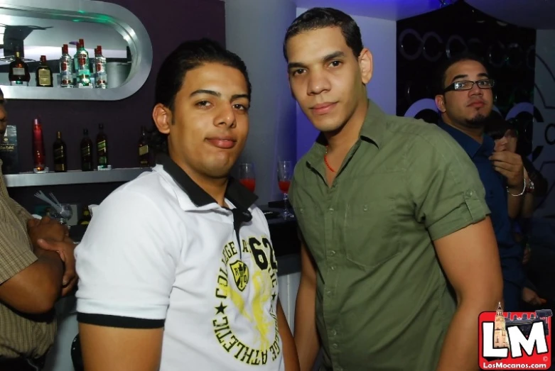 the two men are posing together in a bar