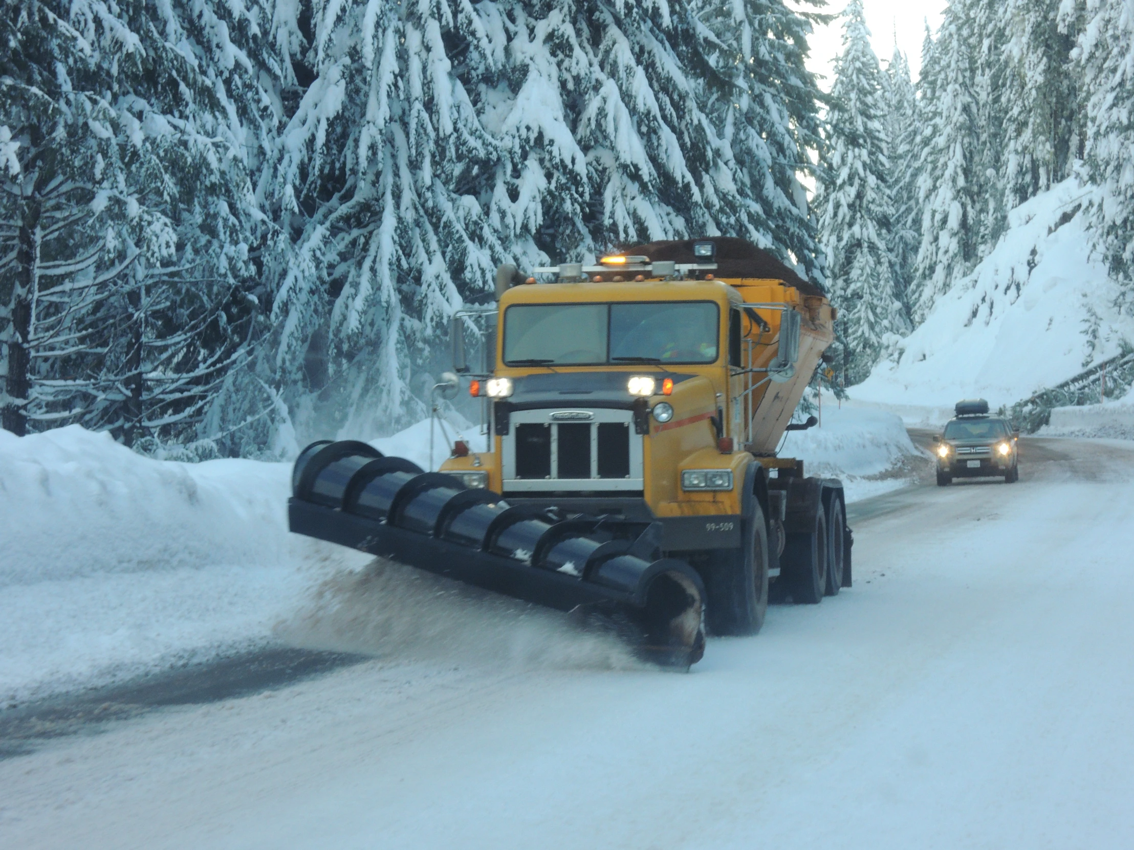 a tractor trailer driving down a snowy road