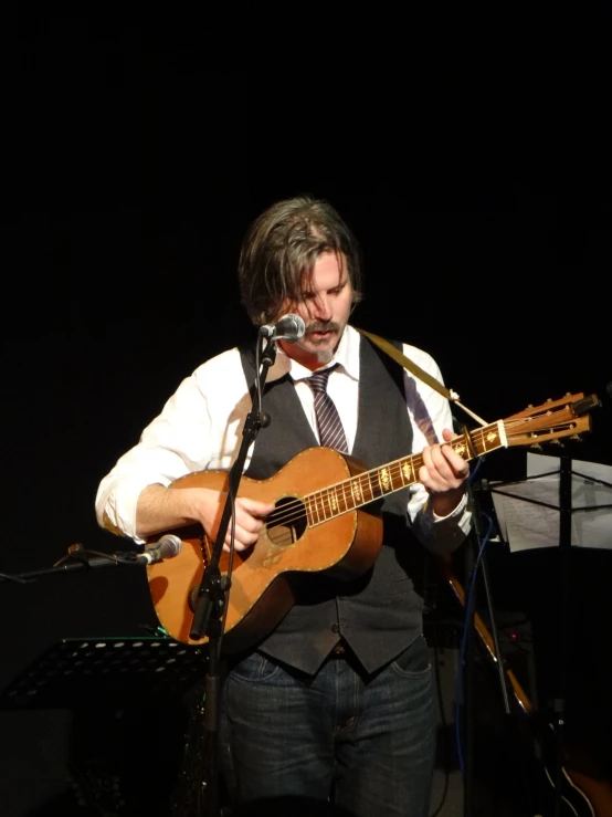 a man is playing a guitar in the dark