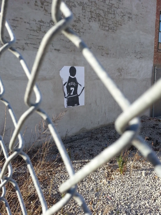 a fence with an advertit on the side of a building