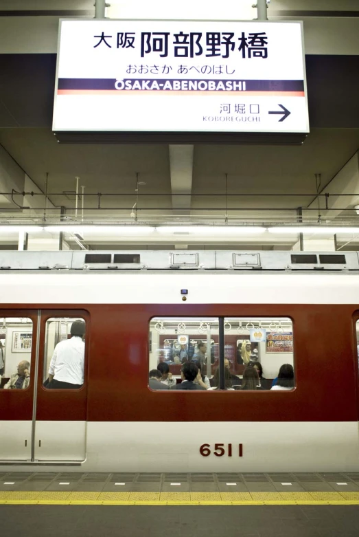 a train pulling up to a station with people waiting on it