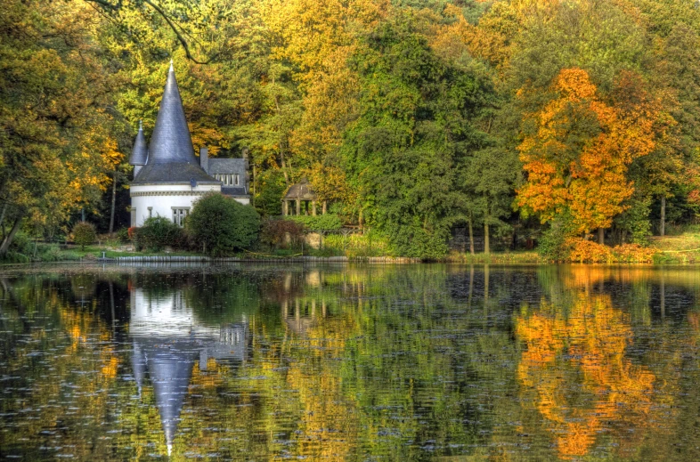 a church stands out amongst the colorful trees in this pograph