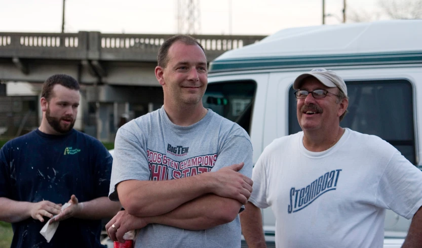 three men and one guy stand in front of an rv