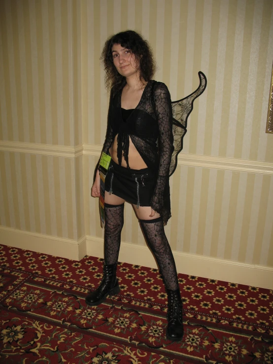 a young woman posing wearing a black lace dress with cut outs