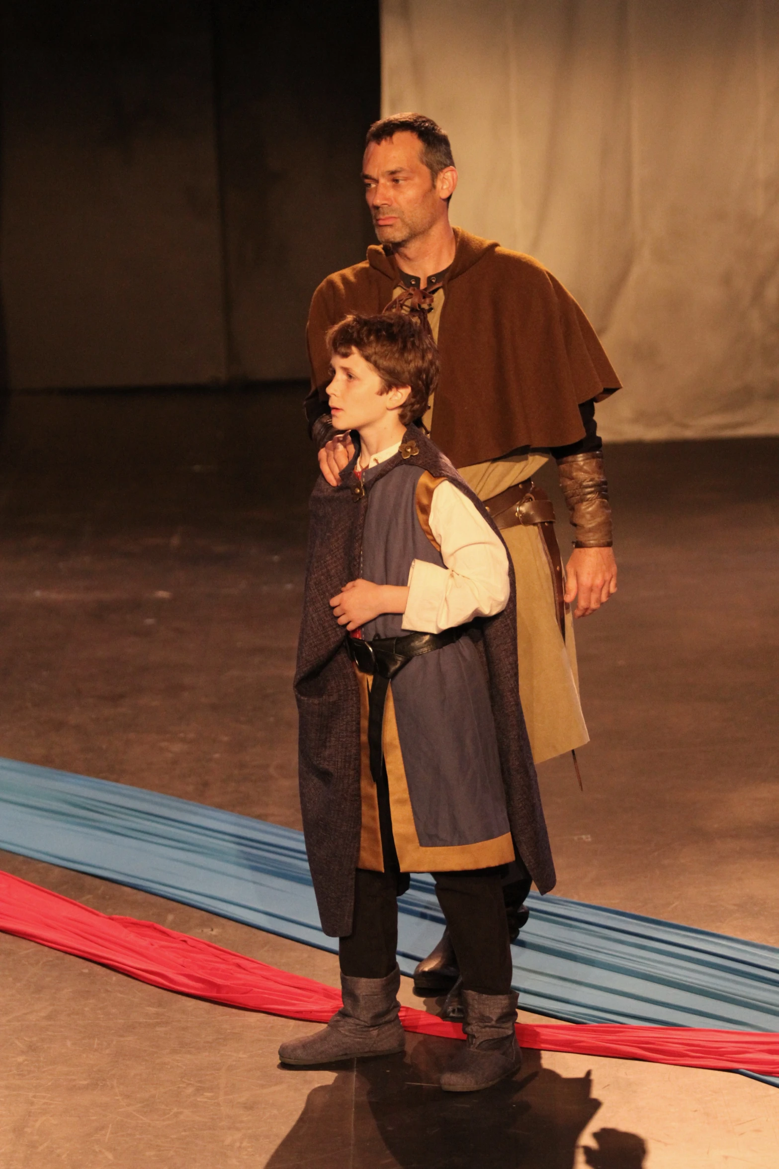 a man and child in renaissance costumes standing in front of each other