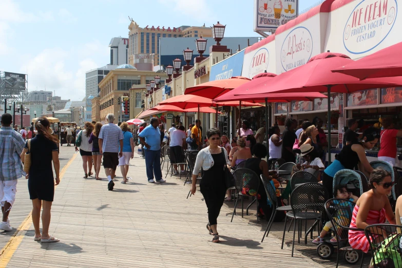 people walking down the sidewalk at an outside shopping area