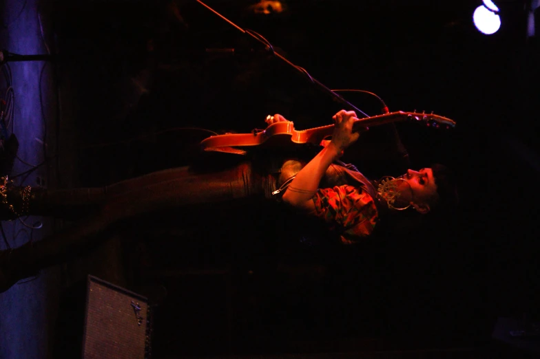 a man with a guitar standing on a stage