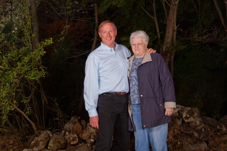 an elderly couple is posing for a picture at night