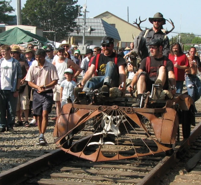 the men are riding an animal on the train tracks