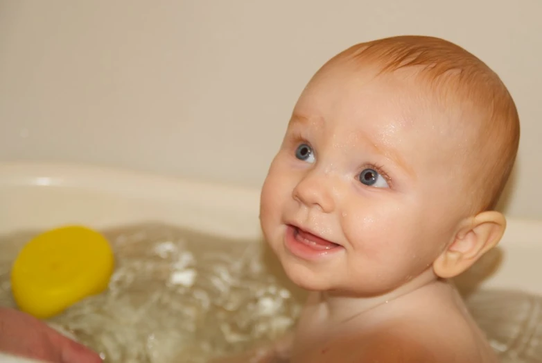 the small child is in the tub in the water