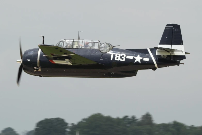 a black and green plane is flying close to the camera