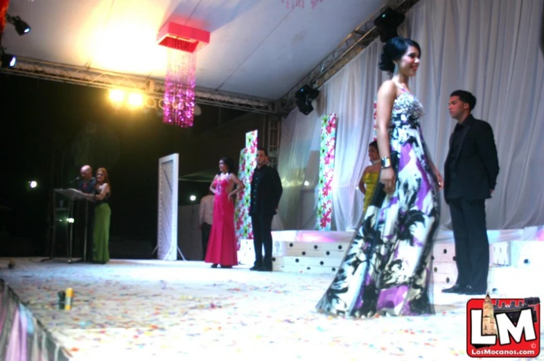 two men and a woman walking down a runway at a fashion show